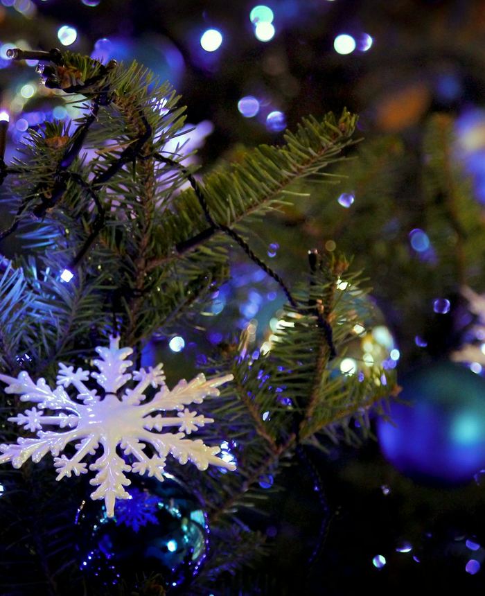 A snowflake ornament on a sparkling Christmas tree