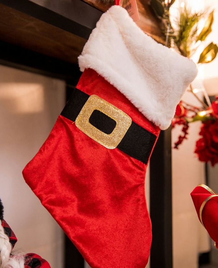 A red Christmas stocking hanging from a mantel
